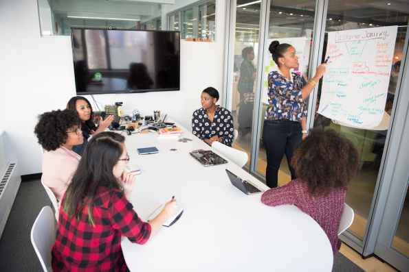 six woman standing and siting inside the room