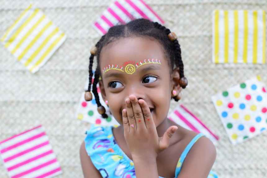 close up photo of smiling girl covering mouth