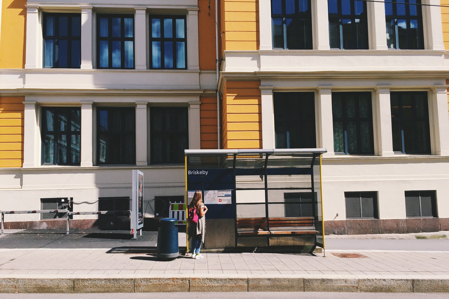 photo of woman standing in waiting shed