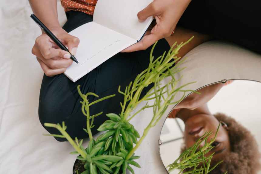 photo of woman writing on notebook